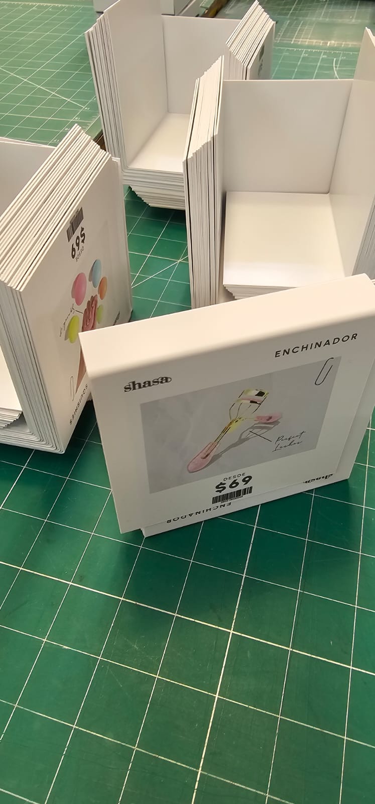 Exhibidores de cartón impresos y armados, apilados en el taller